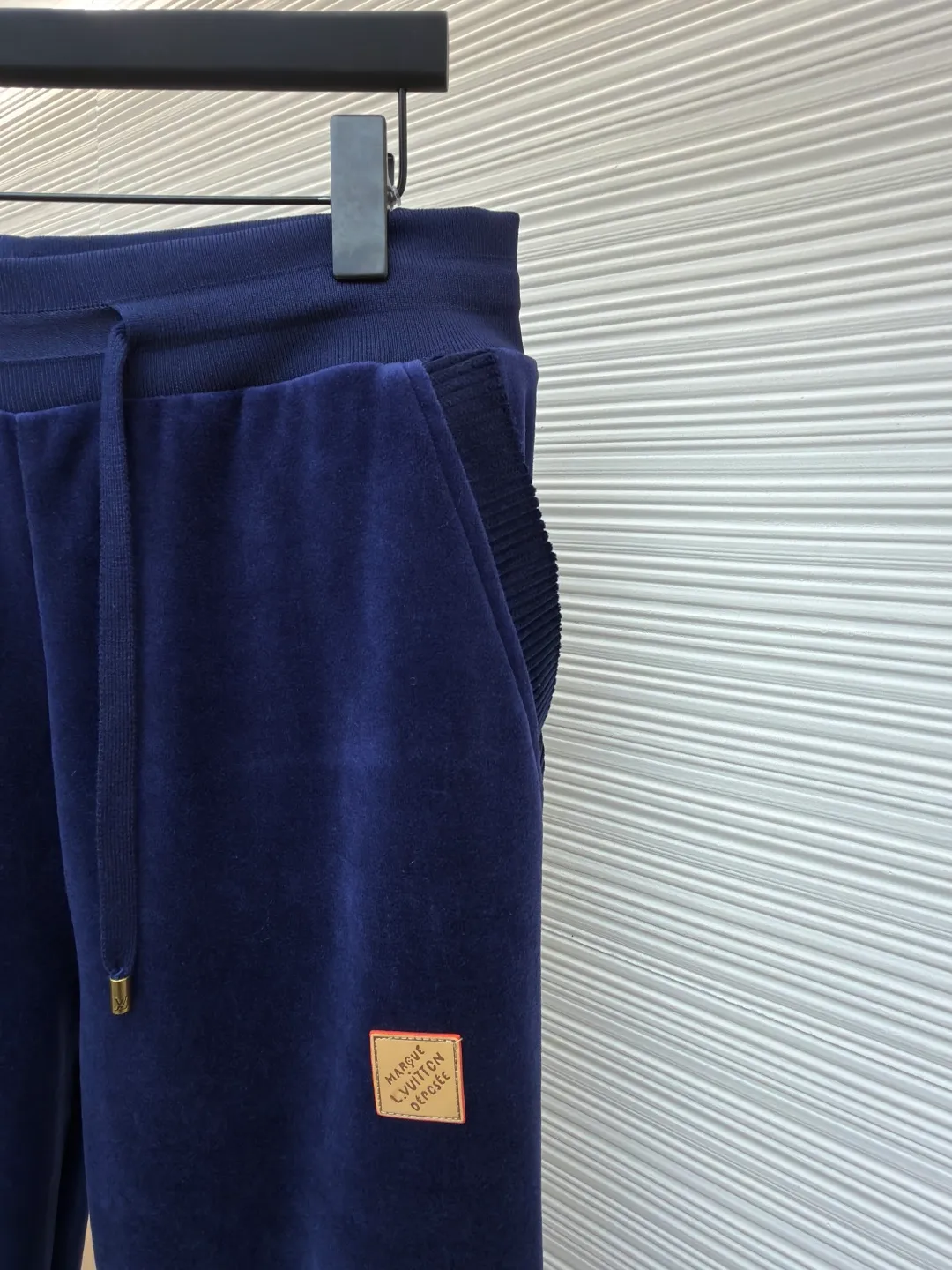 LOUIS VUITTON velvet solid color drawstring straight knitted sweatpants ●Original version: Purchased and developed by 16793 ●Item number: 1682160-B25 ●Fabric: velvet fabric ●Technology: knitting ●Color: navy blue ●Version: fitted version ●Weight: about 470 grams ●Size: S-M-L-XL ●Description: This navy blue leggings sweatpants are made of high-end velvet fabric. The cotton base is blended with polyester fiber treated by combing process, which makes the fabric have a soft and skin-friendly touch and practical performance of not easy to pilling and anti-wrinkle. The suede surface shows a delicate and uniform luster. Every inch of the velvet feel has been calibrated through the fixing process to avoid lint loss and color difference problems. The trousers are three-dimensionally cut, and the waist is equipped with a high-elastic rib drawstring design. The metal rope ends are electroplated and glaze-sealed, which is wear-resistant and has a long-lasting luster. The sides are spliced ​​with vertical pit rib fabric to enhance the extensibility of activities and enhance the three-dimensional sense of the fit. The leather logo plate on the trouser legs is fixed by hot stamping process, and the edges are polished smooth and burr-free. The leg openings are made of high-elastic ribbing of the same fabric. The double-needle hemming process is used for the stitching. The stitch spacing is even and fine. From fabric selection to detail sewing, every process follows strict quality control standards to ensure a balance between firmness and wearing comfort. The overall wiring is straight and delicate, the fabric is comfortable and soft, and the color is consistent without color difference. It can be matched with the same style to create a fashionable look and control various occasions. Customized accessories, complete with three standards, same style for men and women!